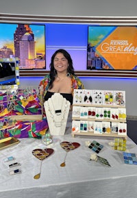 a woman is standing in front of a table full of jewelry